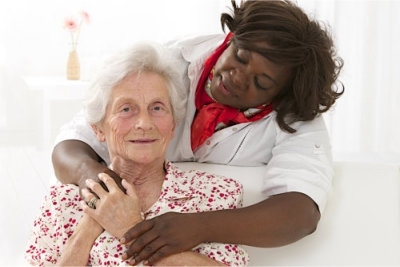happy senior woman with friendly african american caregiver